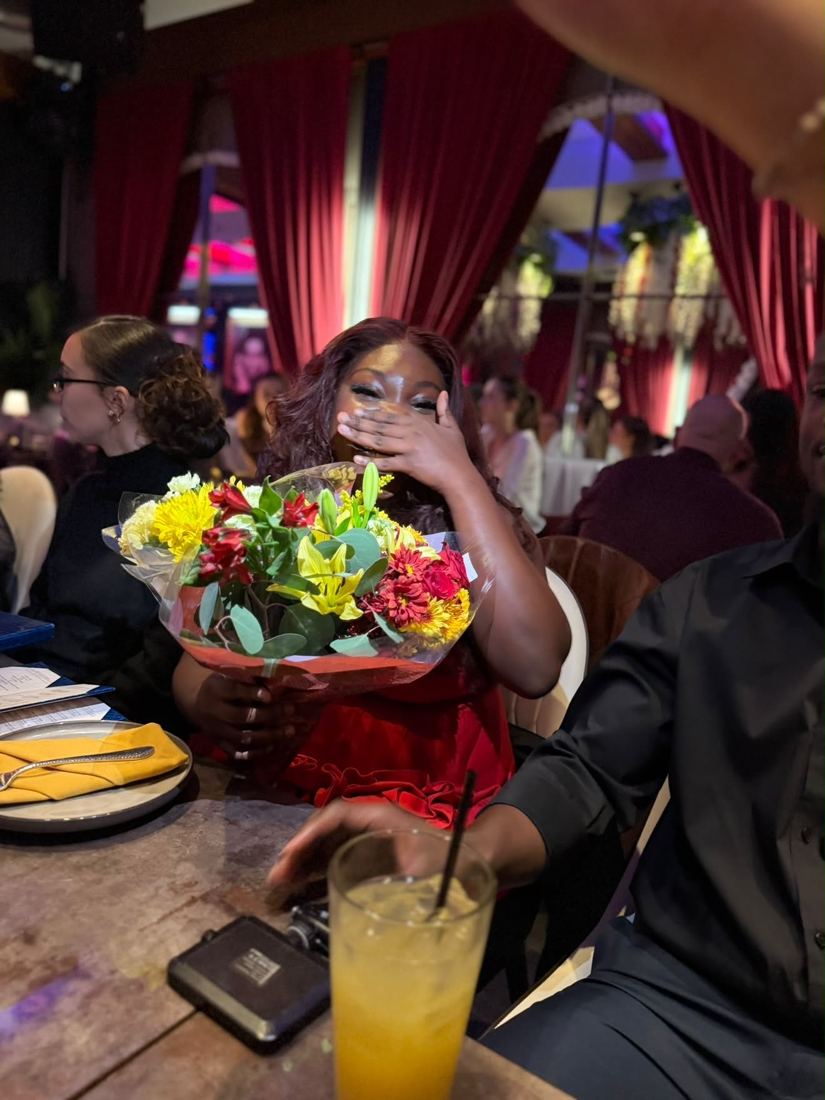 Gizelle covering her face as she holds her flowers