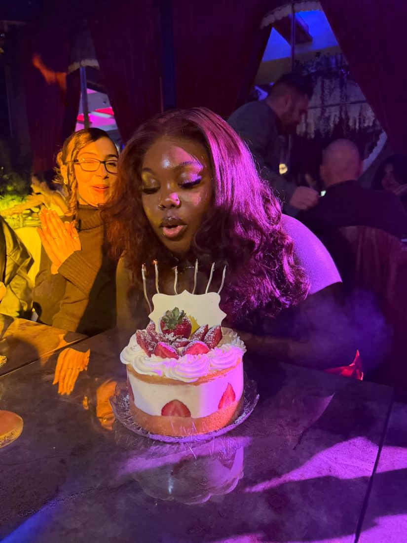 Gizelle blowing out the candles under purple light
